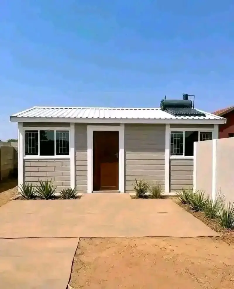Finished precast home with white roof and solar water heater